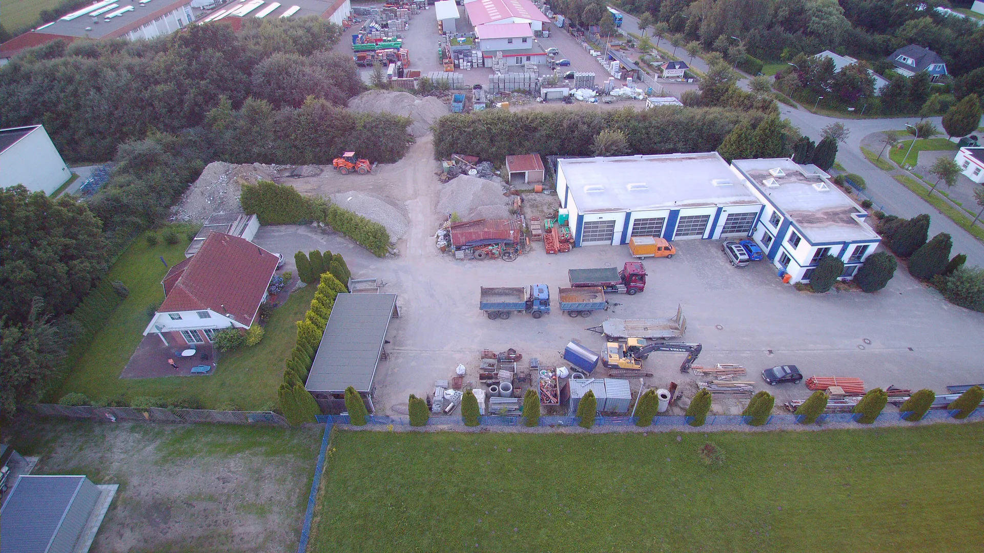 Luftaufnahme des Betriebsgeländes von Erdbau-Friedel mit Hallen, Lagerflächen und Fuhrpark