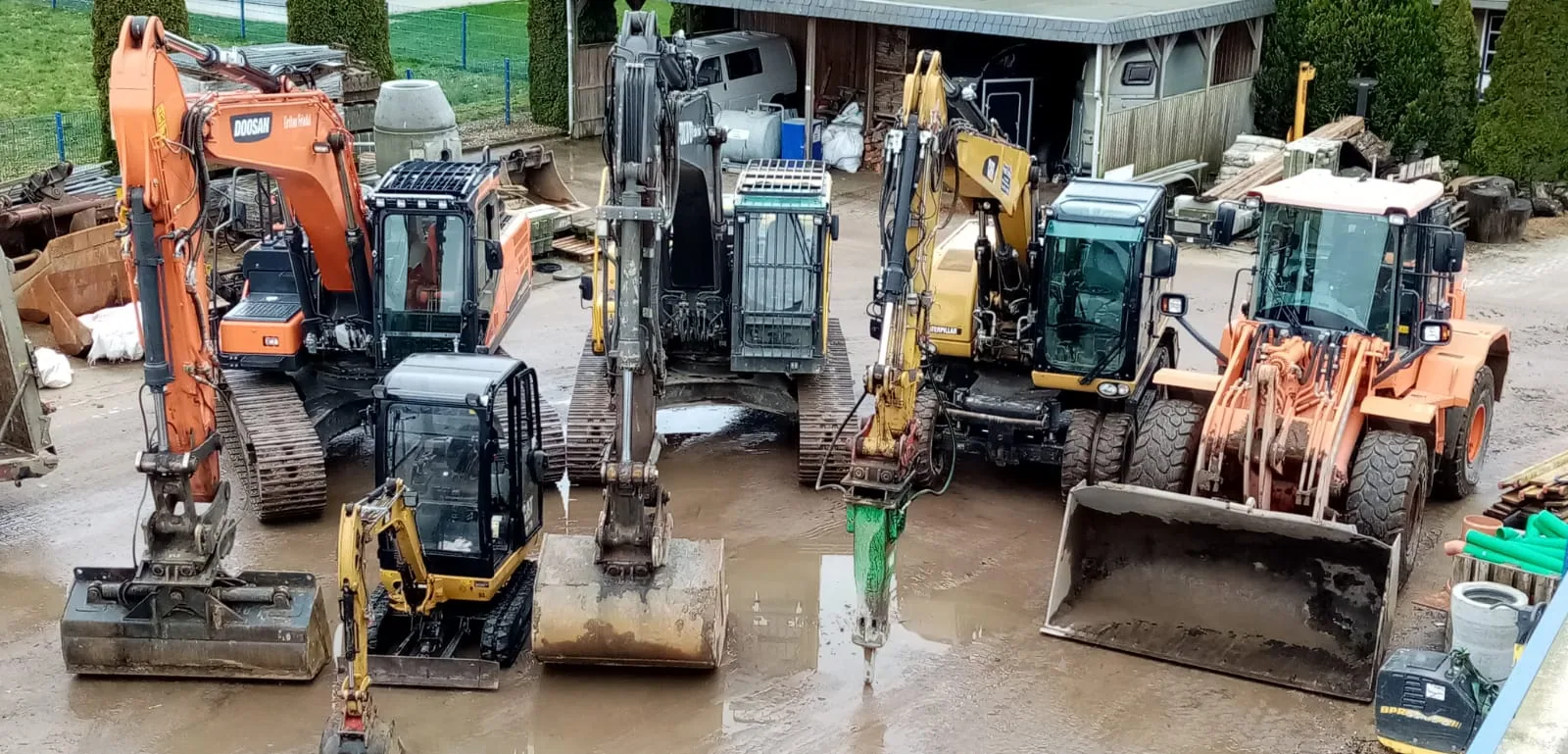Aufgereihte Bagger und Radlader im Maschinenpark von Erdbau-Friedel