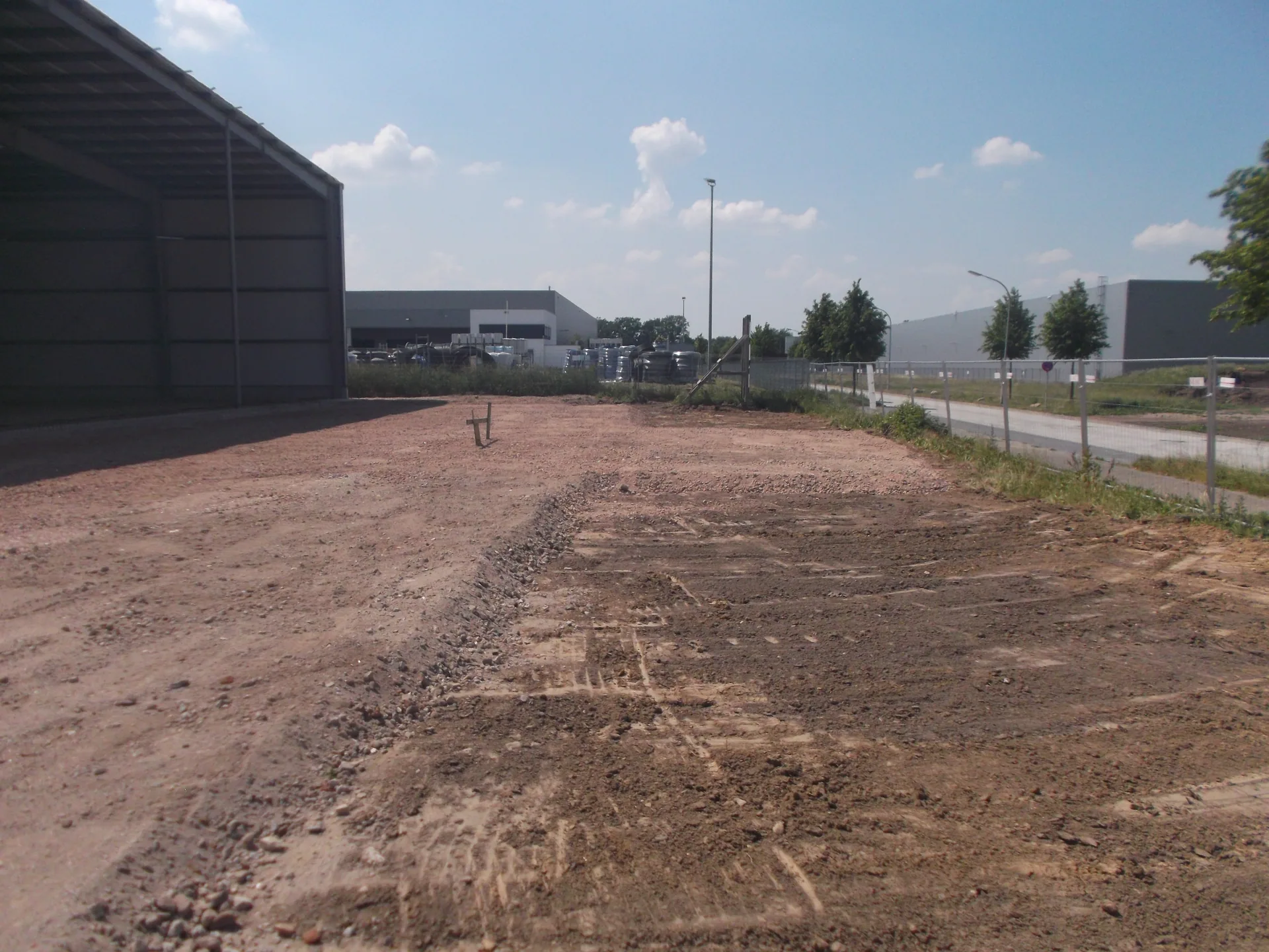 Befestigte Freifläche mit Unterbau neben einer Halle